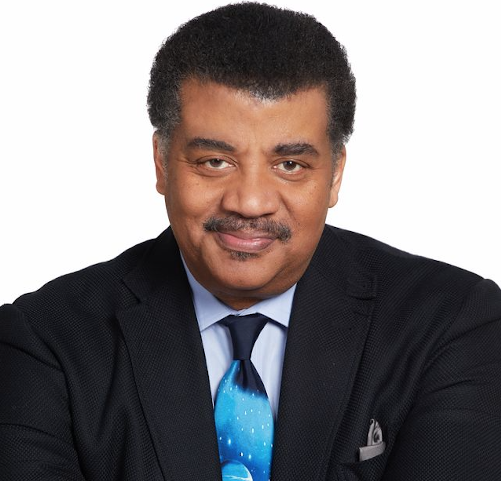 a man in a dark suit wearing an astronomy tie