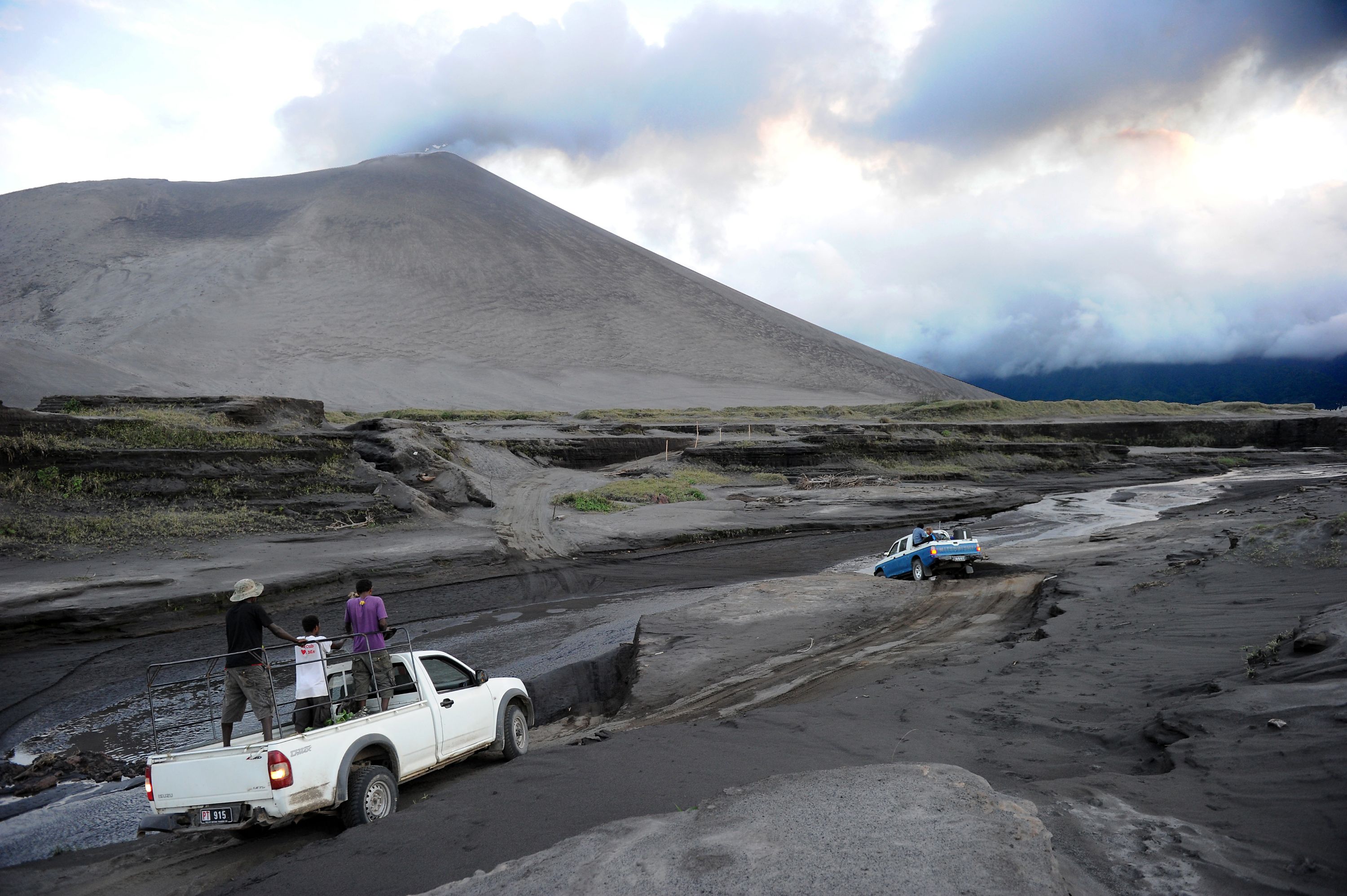 Mount Yasur with cars crossing the lava plains