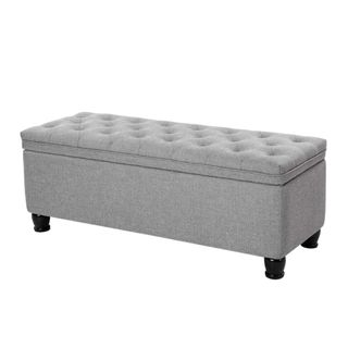 A gray rectangular storage ottoman with a tufted button top and wooden legs
