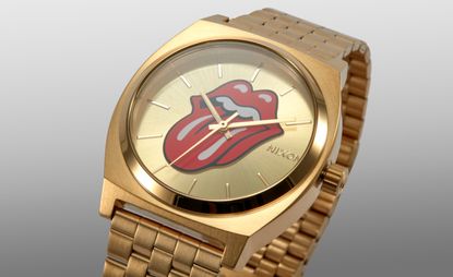 A gold watch with a tongue sticking out of red lips on its face.