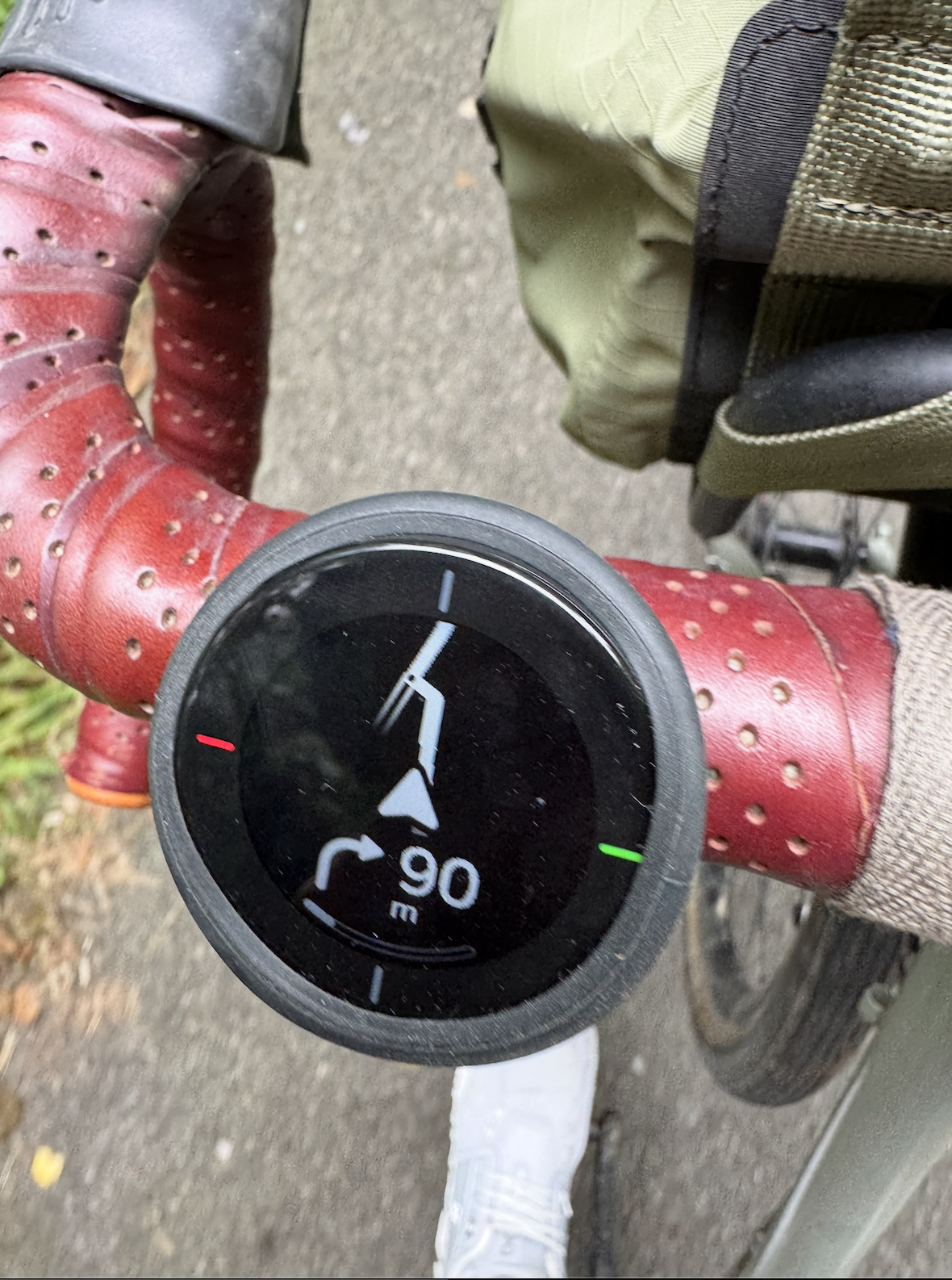 A small GPS on the handlebars, depicting a simple navigation of right turn 90m and a line drawing of a junction.