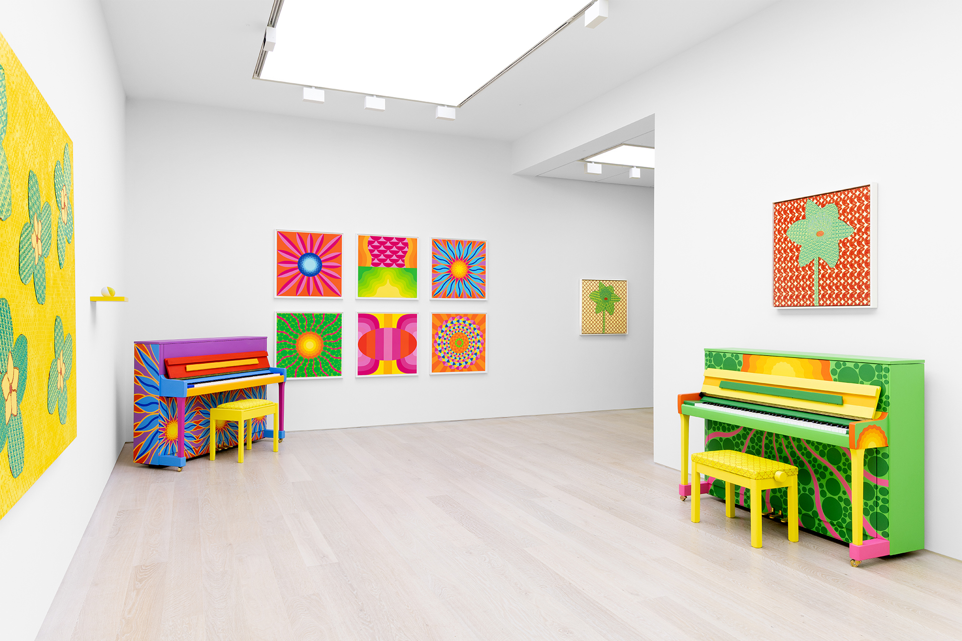 Gallery featuring two pianos and motif artwork on the wall