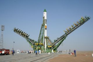 Peoole surround the Soyuz-U launch vehicle on the launch pad, as it prepares to launch the Progress M12-M cargo vehicle.