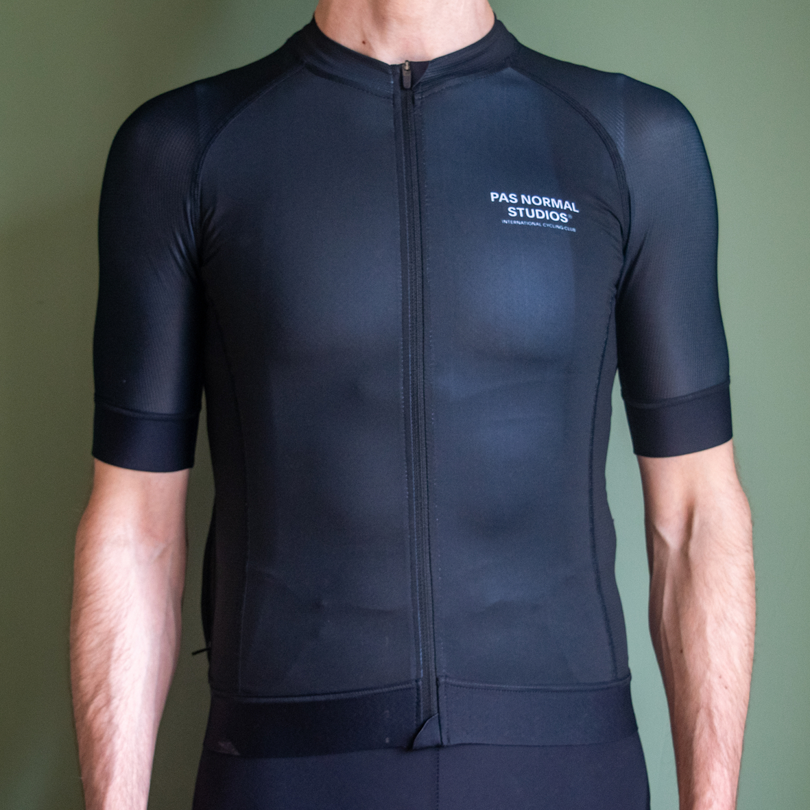 Pas Normal Studios Mechanism jersey being worn against a green background