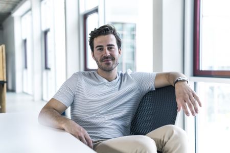 Portrait of smiling professional relaxing in modern office