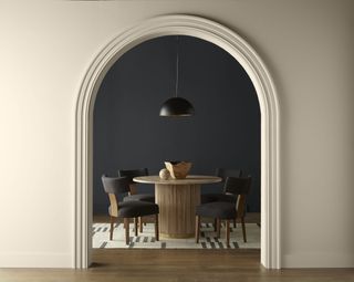 a dark grey dining space with a beige wall in front