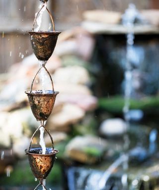 Unique copper cups used as a garden water fountain.