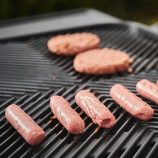 Sausages and burgers cooking on Everdure Force