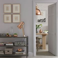 white hallway with low grey shelves and table lamp
