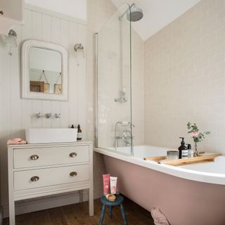 Neutral bathroom with panelled walls and pink bath