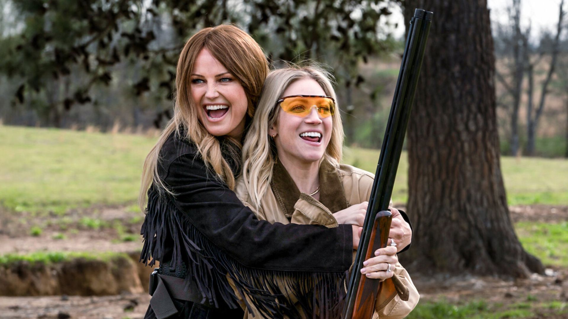 Malin Akerman holds Brittany Snow in an embrace, who&#039;s holding a shotgun