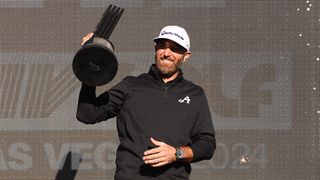 Dustin Johnson celebrating with the LIV Golf Las Vegas trophy