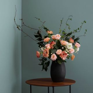 A blue-gray wall with a floral bouquet in front