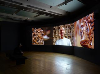 Theatre with Three-channel video installation showing 2 sculptures and one man