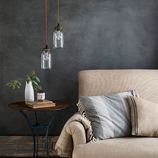 Glass pendant lights above wooden side table and neutral sofa