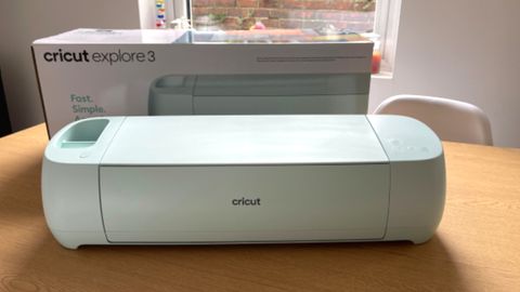 A photo of the Cricut Explore 3 on a wooden table, taken for a review