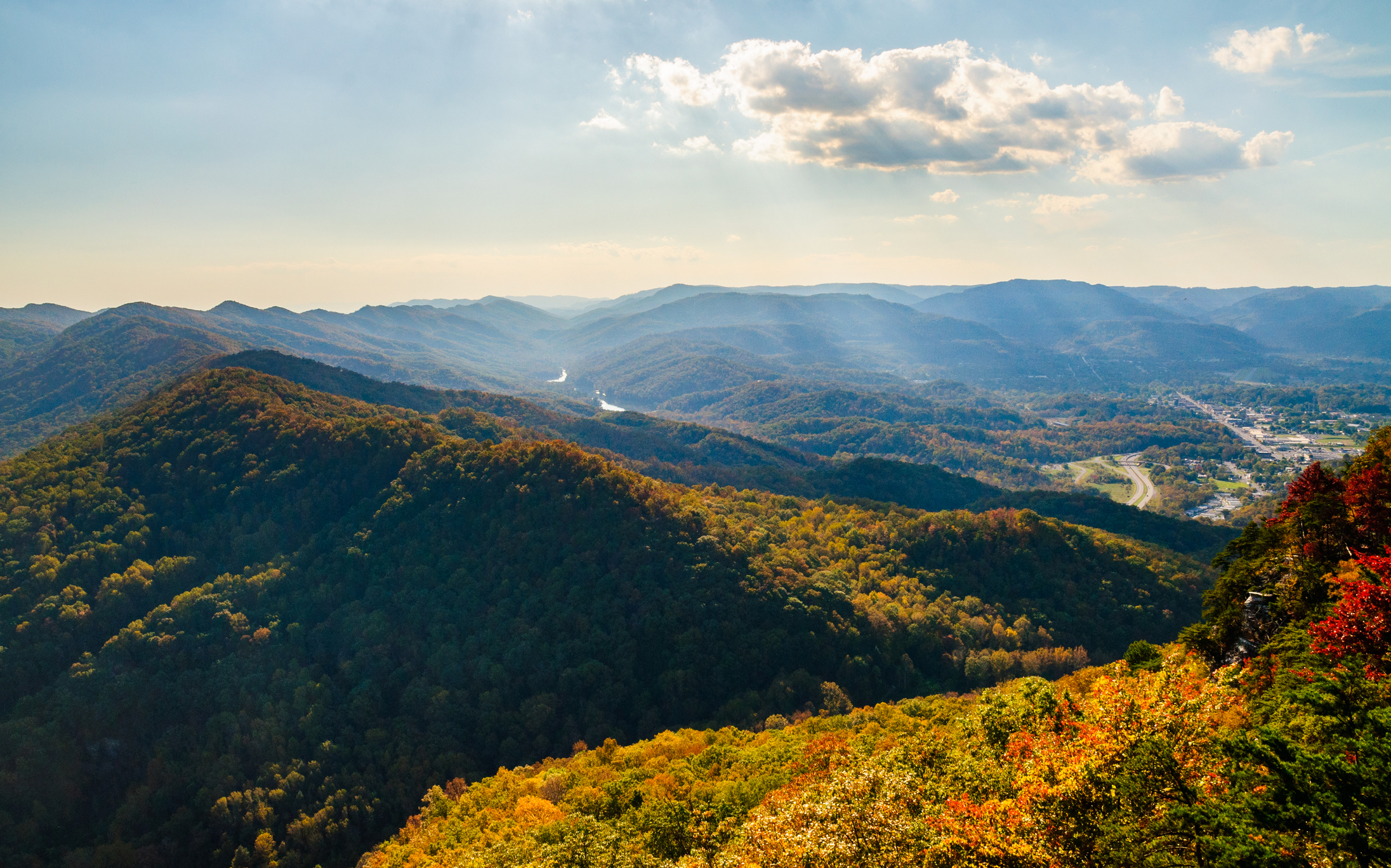 Photo of the Cumberland Gap National Historical Park midday with sunlight streaming down on autumnal colors
