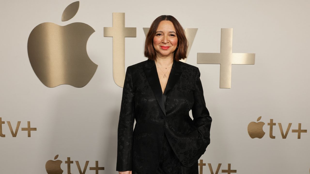 Actor Maya Rudolph stands in front of the Apple Tv+ logo. 