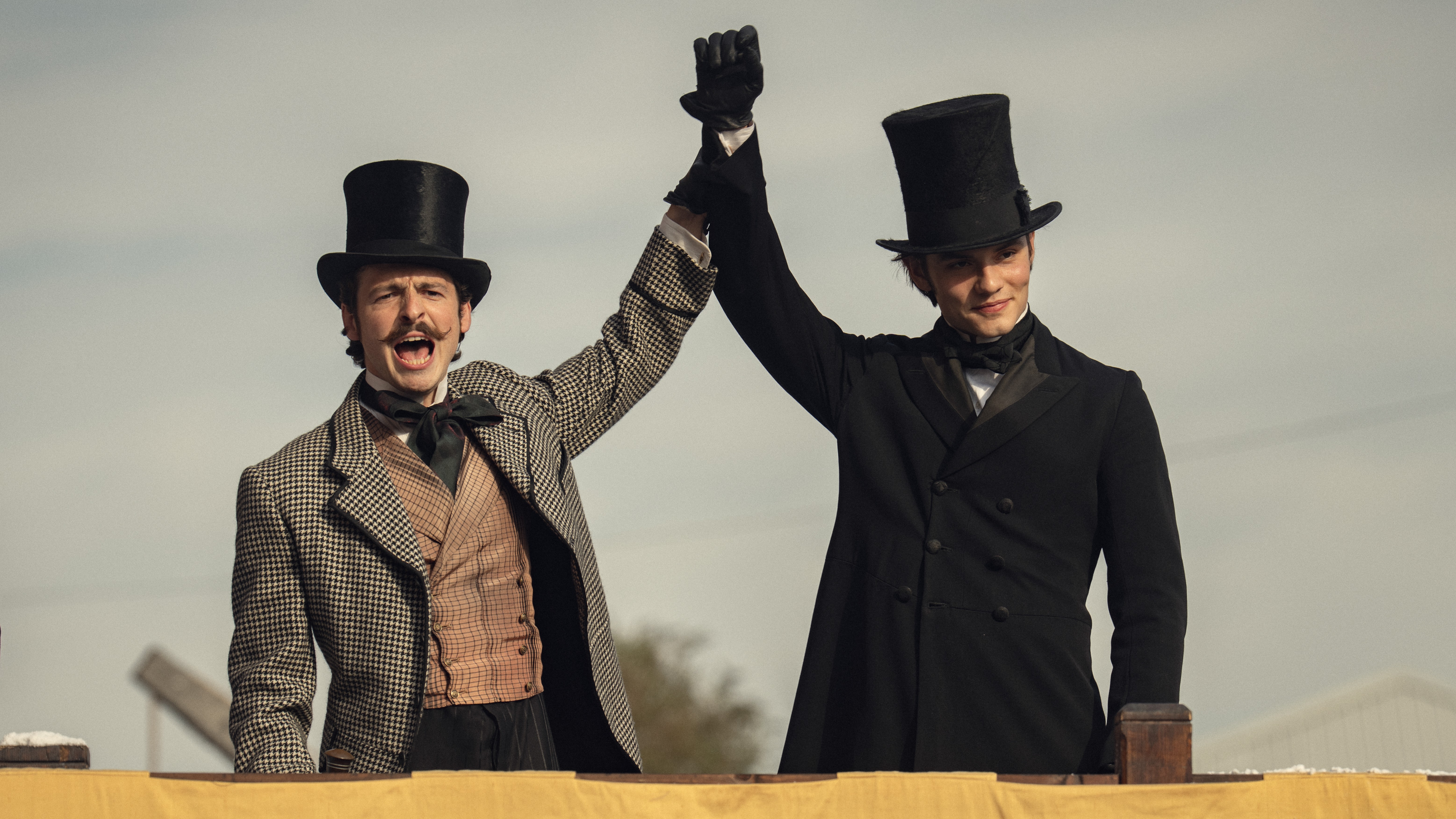 L-R: Anthony Boyle and Louis Partridge standing and shouting in a scene from Netflix's "House of Guinness"