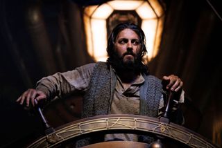 a bearded man at the steering wheel of a steampunk submarine