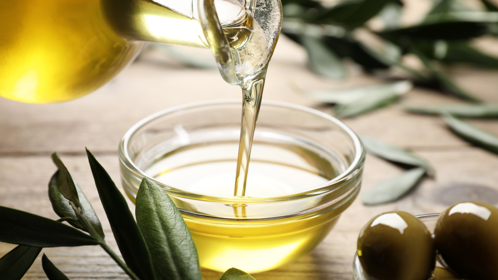 Olive oil being poured into a small dish on a table