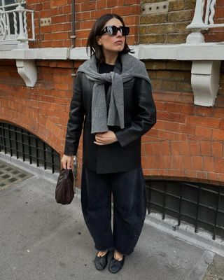  @lucyalston_ wears a leather blazer with barrel jeans and ballet flats