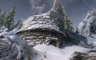Best Skyrim mods — a ruined tower, with its (potentially usable) entrance half-buried in a snowdrift.