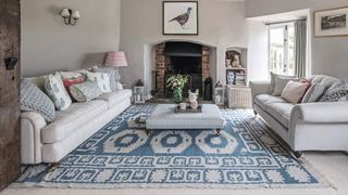 pale gray living room with oversized blue pattern rug to avoid common small rug interior design mistakes
