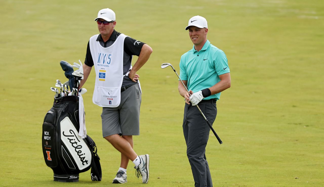 Hardy hits a shot whilst his caddie looks on