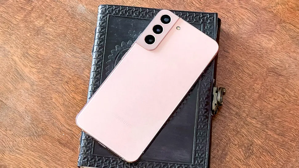 galaxy s22 plus em rosa deitado no livro encadernado em couro