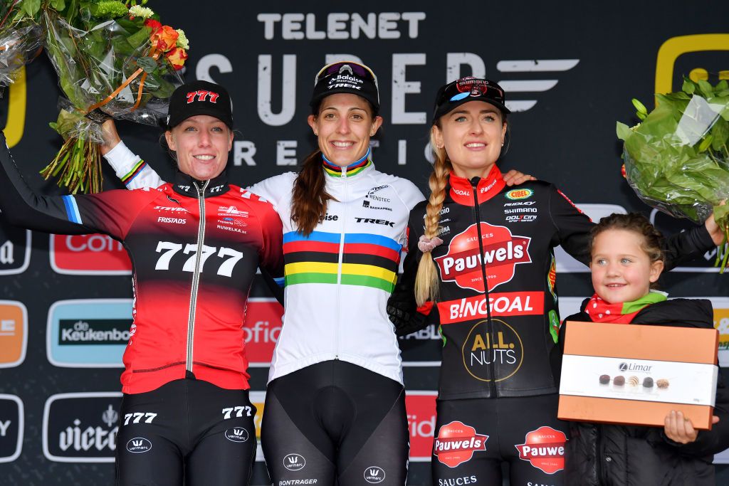 RIJKEVORSEL BELGIUM NOVEMBER 20 LR Annemarie Worst of The Netherlands and Team 777 on second place race winner Lucinda Brand of The Netherland and Team Baloise Trek Lions and Denise Betsema of The Netherlands and Team Pauwels Sauzen Bingoal on third place accompanied by her daughter pose on the podium during the podium ceremony after the 10th Superprestige Merksplas 2021 Womens Elite Superprestige2022 SPMerksplas on November 20 2021 in Rijkevorsel Belgium Photo by Luc ClaessenGetty Images
