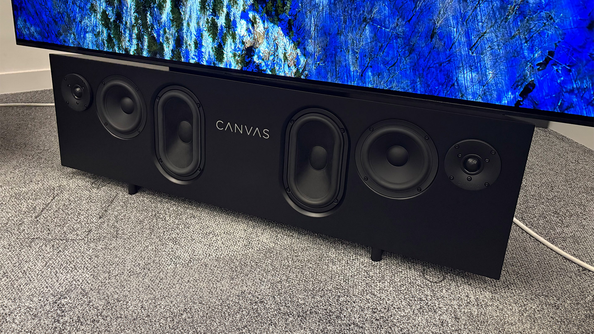 Canvas Hifi 65 soundbar on grey carpet with TV attached