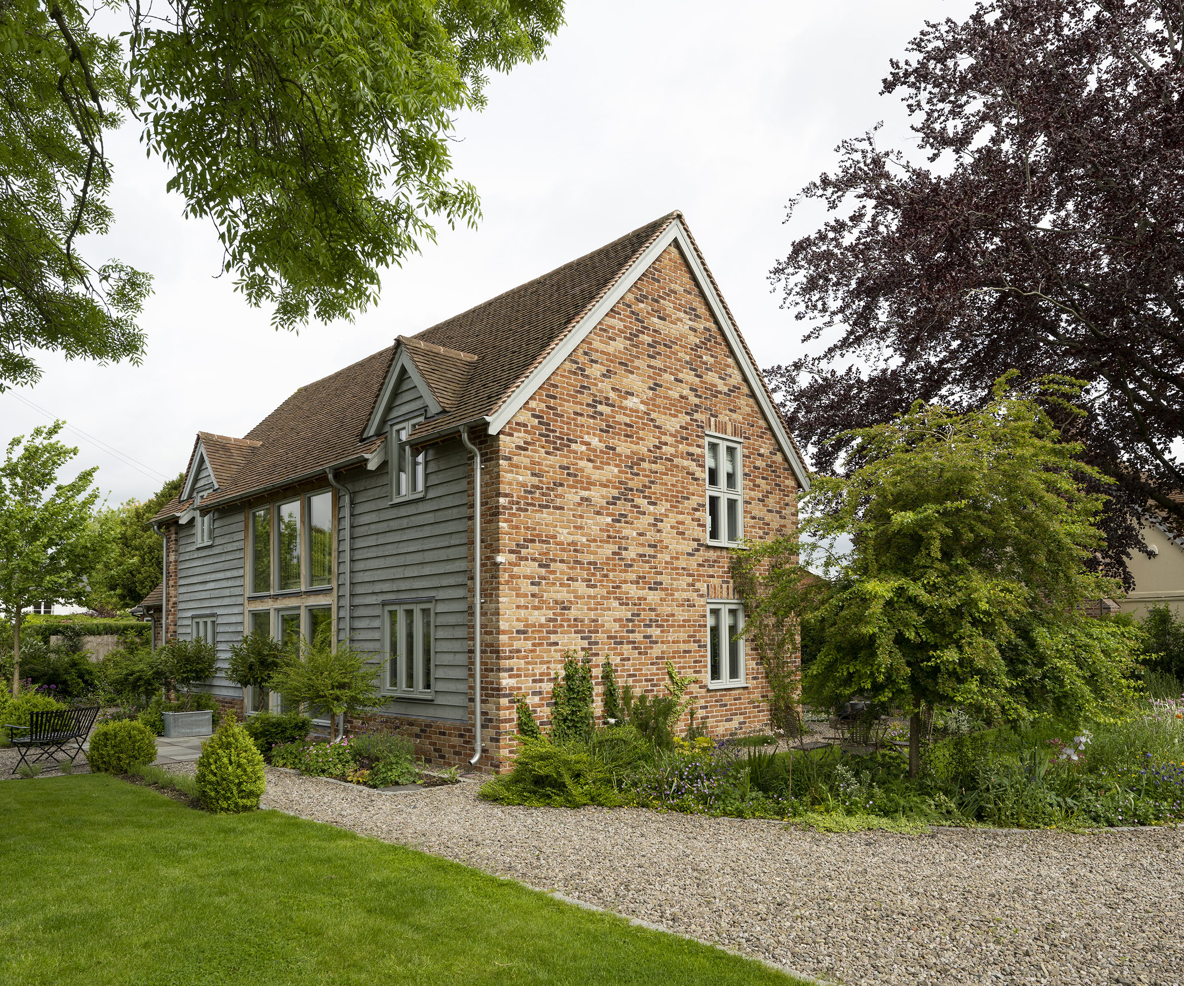 Exterior of a two storey oak frame house with brick and wood cladding