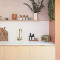 Kitchen sink in pink and wood kitchen.