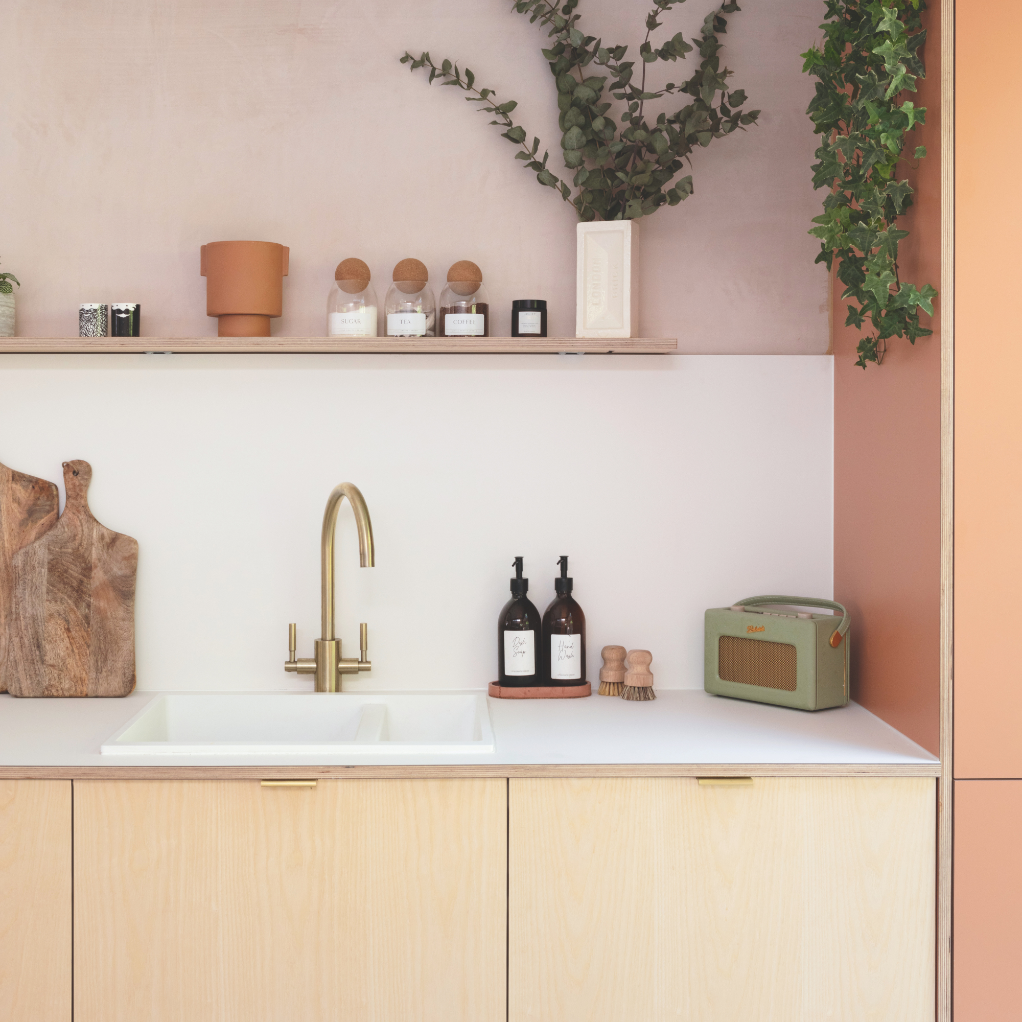Kitchen sink in pink and wood kitchen.