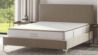 The Saatva Memory Foam Hybrid Mattress, shown here on a beige bedframe, is on sale every month