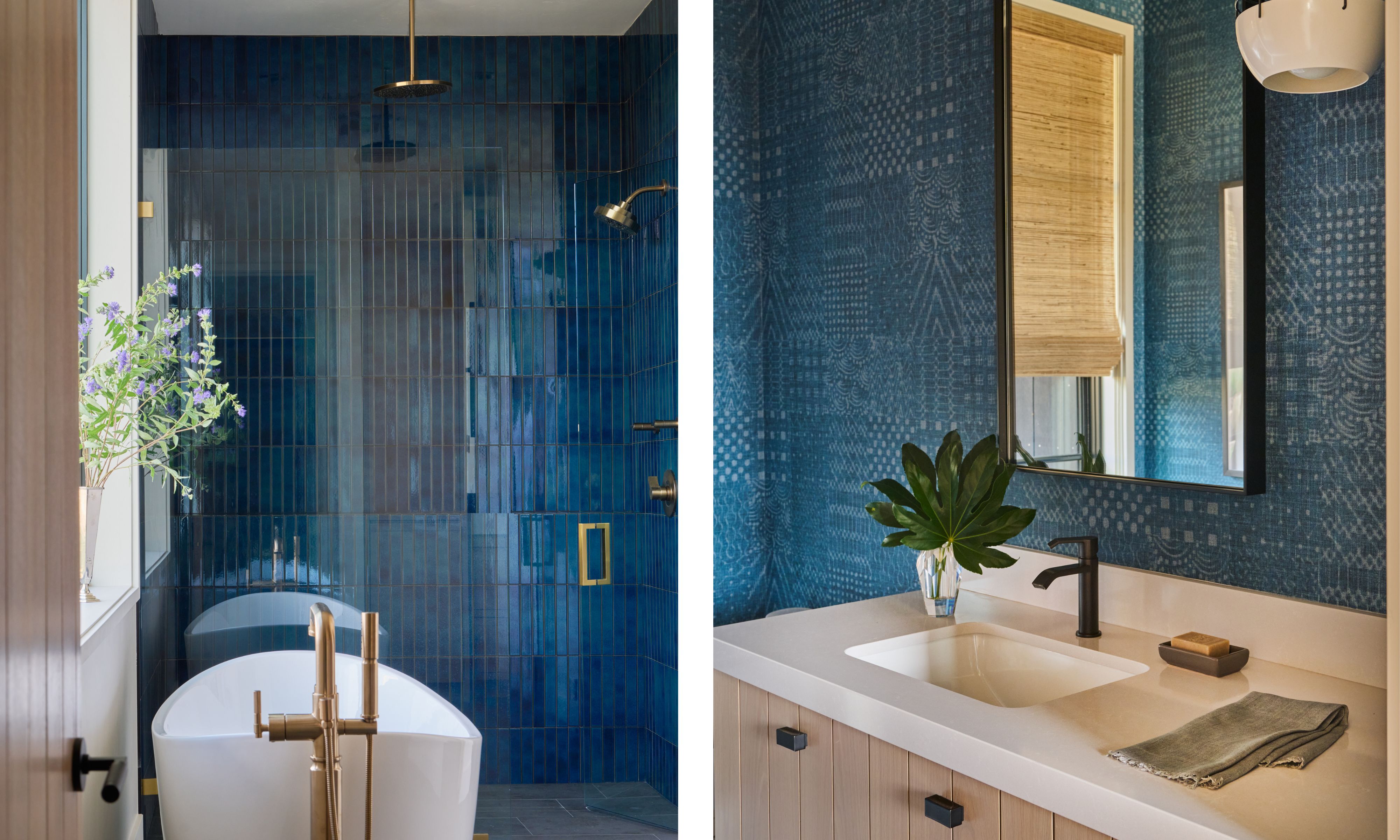 Left image: A modern bathroom with a freestanding white tub in front of a deep glossy blue tiled wall. A vase with purple flowers sits on the windowsill. Right image: A stylish vanity area with a white countertop and under-mount sink. The wall is covered in a patterned blue wallpaper. There is a black matte faucet and a simple gold framed mirror above the sink. A glass vase with broad green leaves and a folded towel sink on the surface of the vanity.