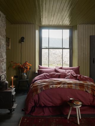 Cabin style cozy bedroom with paneling and Piglet in Bed plaid brushed cotton bedding in berry red