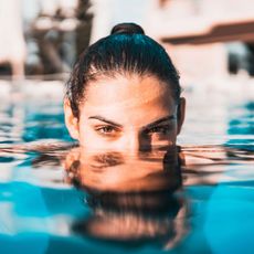 woman in a pool wearing sunscreen