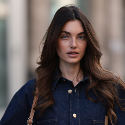 Hairbrush: Celine Bethmann seen wearing Cie Cie oversized dark-wash denim button-up western-inspired shirt with a relaxed fit, vintage brown / tan suede leather handbag with braided handles and fringe elements, on March 21, 2025 in Berlin, Germany.