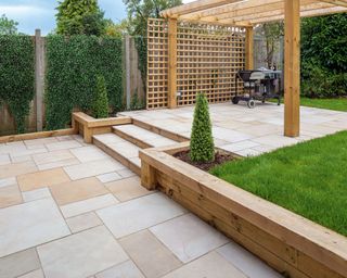 paved patio with a timber pergola over a section of it