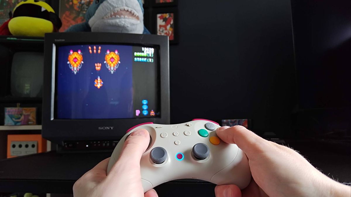 Hands using Gulikit Elves 2 Pro to play Truxton on a Sega Mega Drive connected to a Sony Trinitron CRT TV.