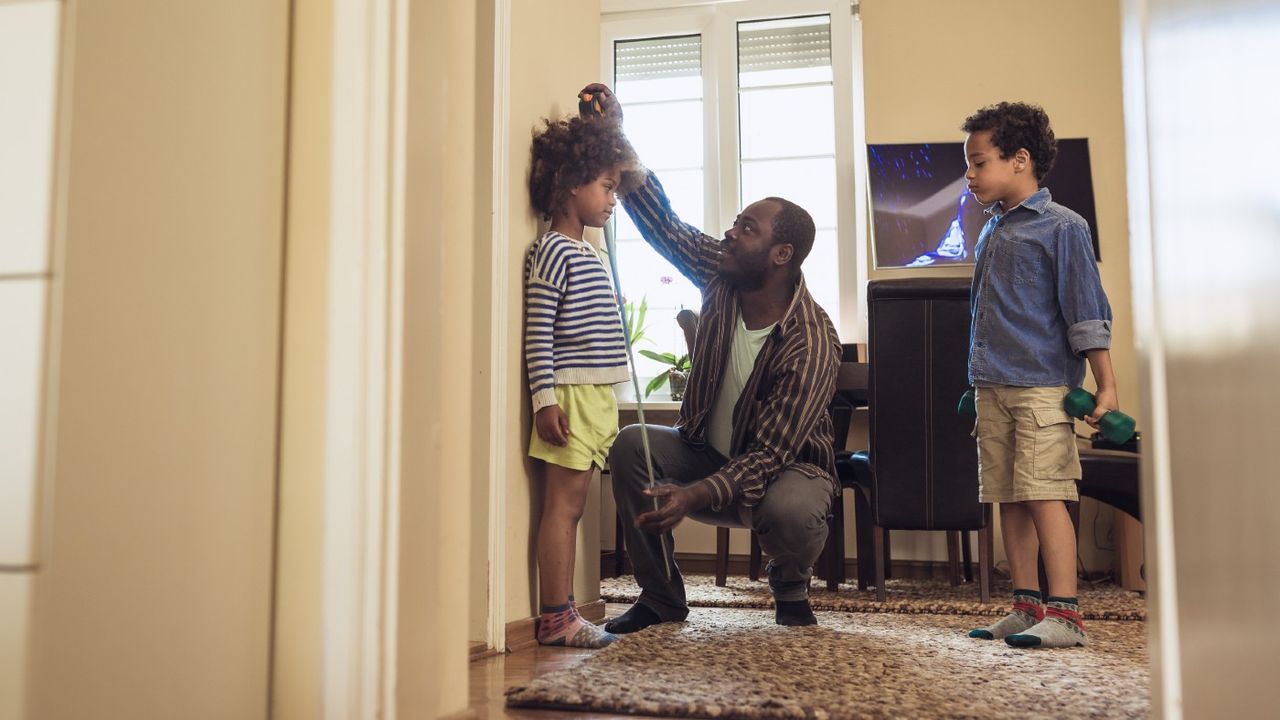 Dad measuring his daughter&amp;#039;s height