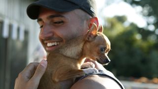 Chihuahua on smiling man's shoulder