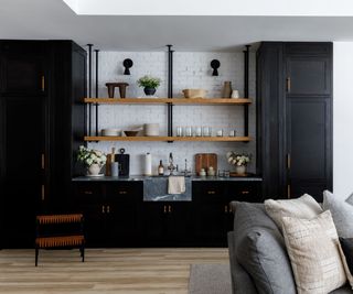 i-shaped kitchen with black cabinets and wooden floating shelves