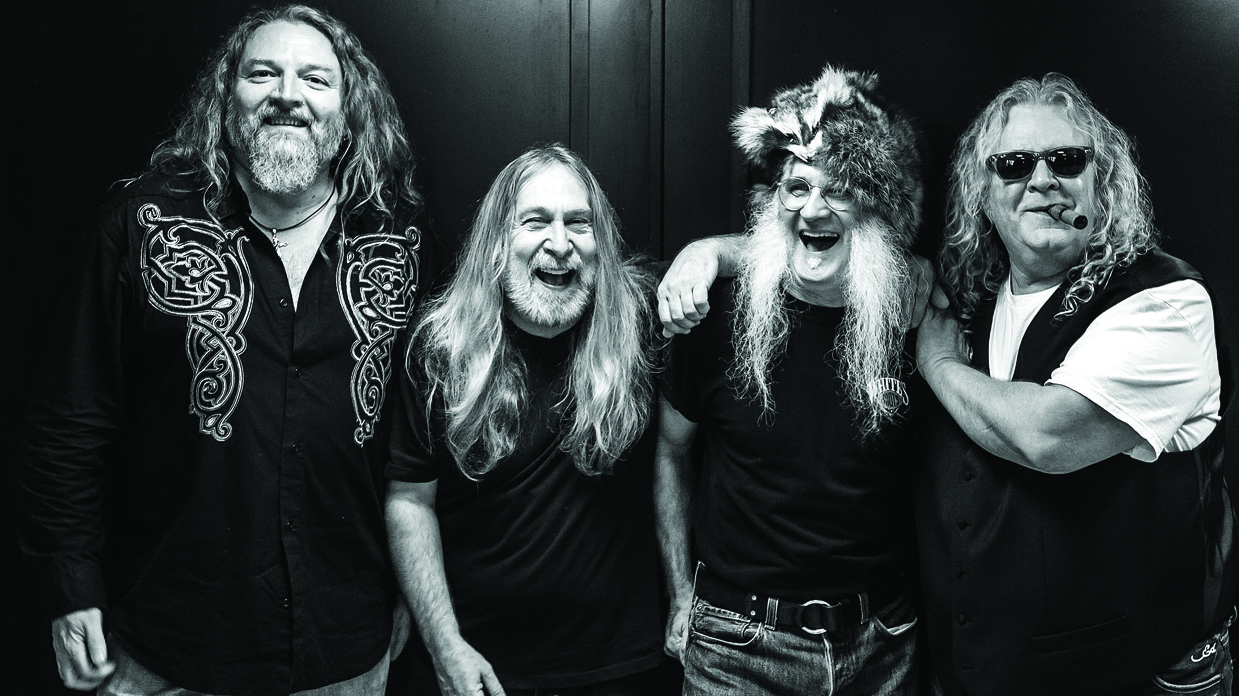 A black and white picture of The Kentucky Headhunters standing in a line and smiling.