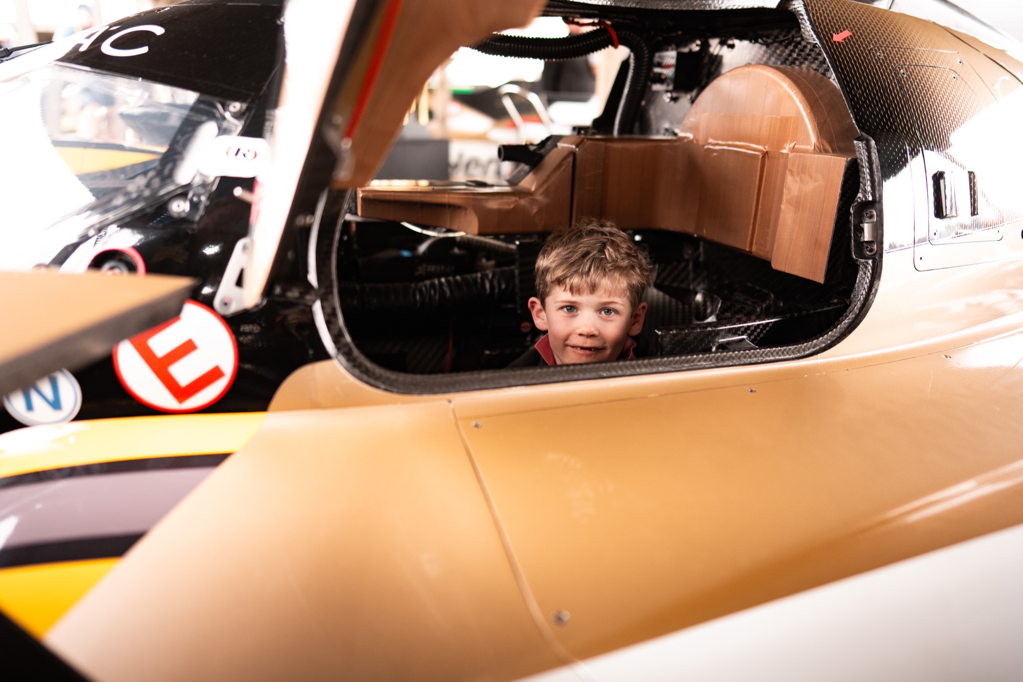 A young boy photographed in the cockpit of a racecar
