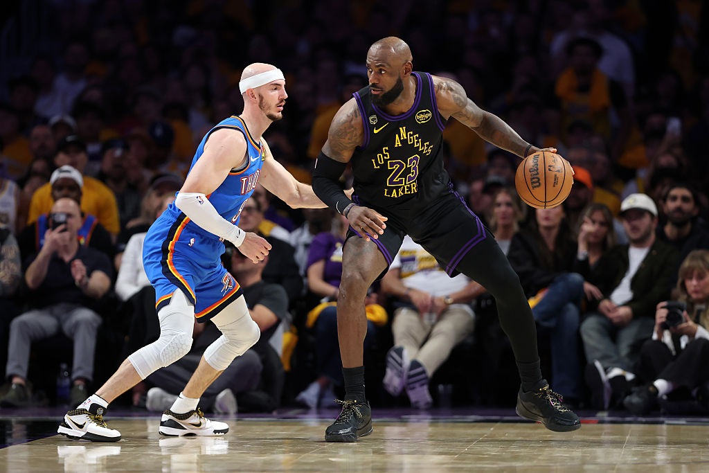 LeBron James #23 of the Los Angeles Lakers dribbles against Alex Caruso #9 of the Oklahoma City Thunder during the fourth quarter in Game Four of the Second Round of the NBA Western Conference Playoffs at Crypto.com Arena on May 11, 2026 in Los Angeles, California (Photo by Luke Hales/Getty Images)