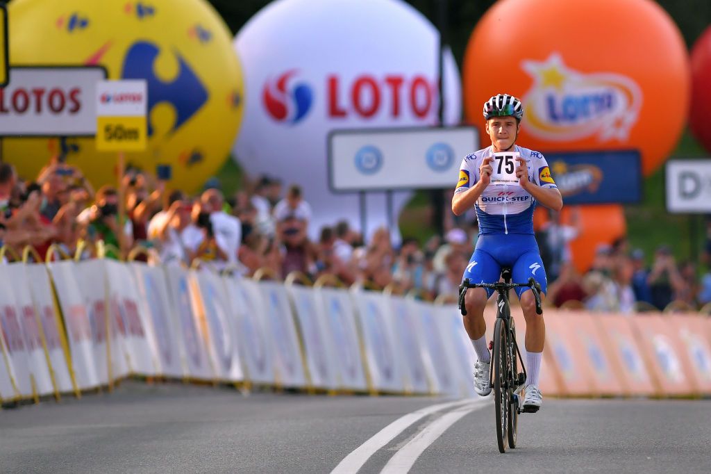 Evenepoel holds up Jakobsen's race number in the home straight