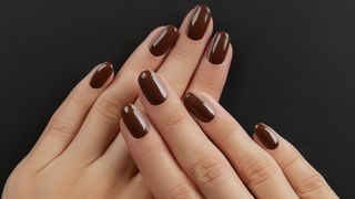 Hands with brown nail polish